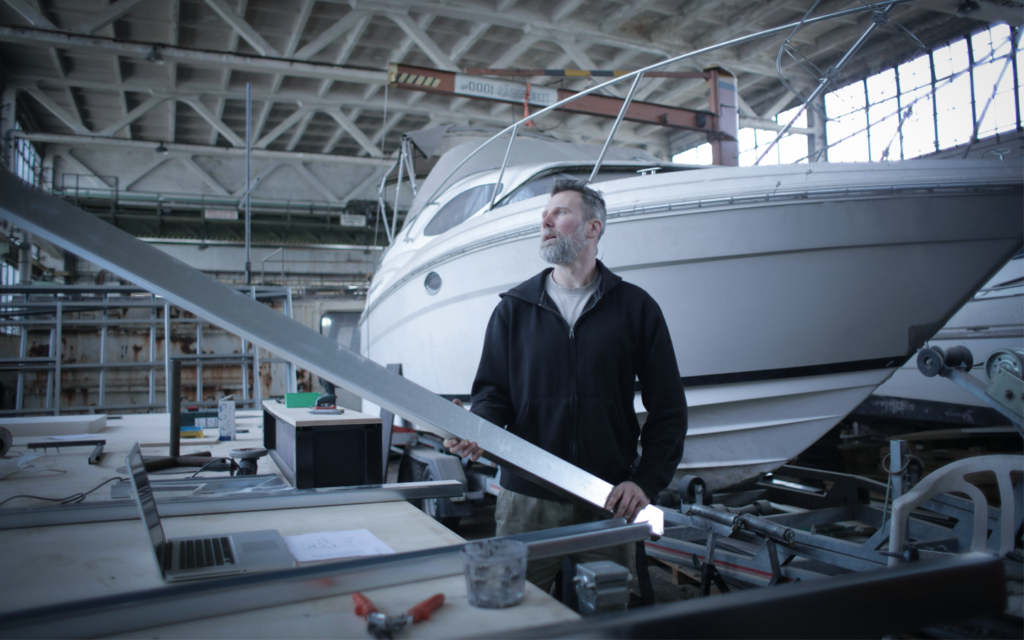 a man holding metal part near boat Laser cutting for hobbyists